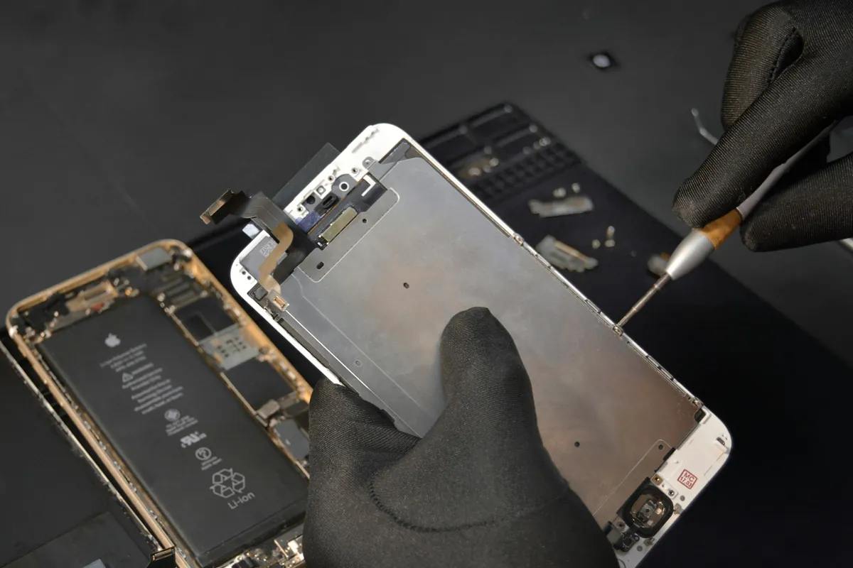 Démontage de l'écran d'un téléphone à l'atelier