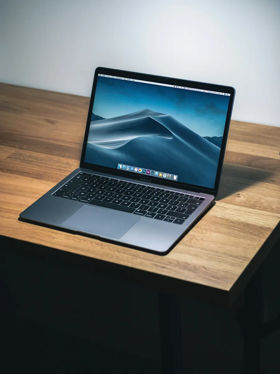 MacBook ouvert sur un bureau en bois